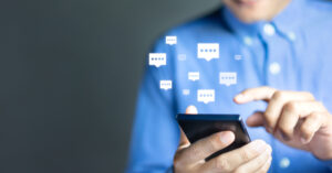 Individual in a blue shirt sending online messages to a chatbot.