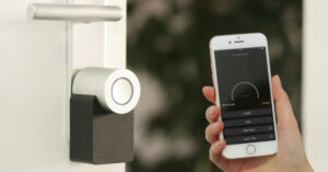 hand holding a cell phone up to a security camera