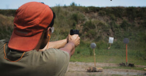 a man shooting a gun at a firing range