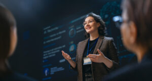 A charismatic businesswoman delivers a dynamic and engaging presentation on technology in a modern conference room, inspiring her audience with leadership and knowledge. The atmosphere is professional, empowering, and filled with anticipation for groundbreaking ideas.
