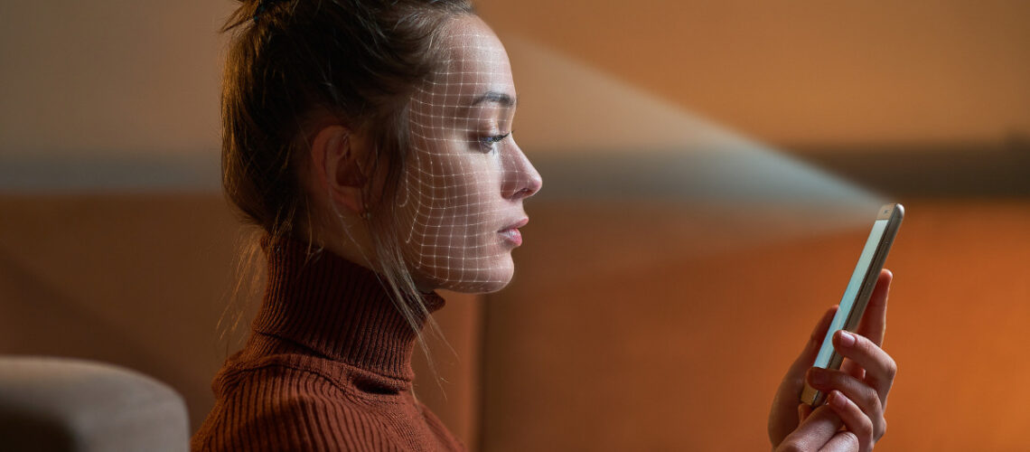 deep fake technology scanning woman's face who's holding a smartphone
