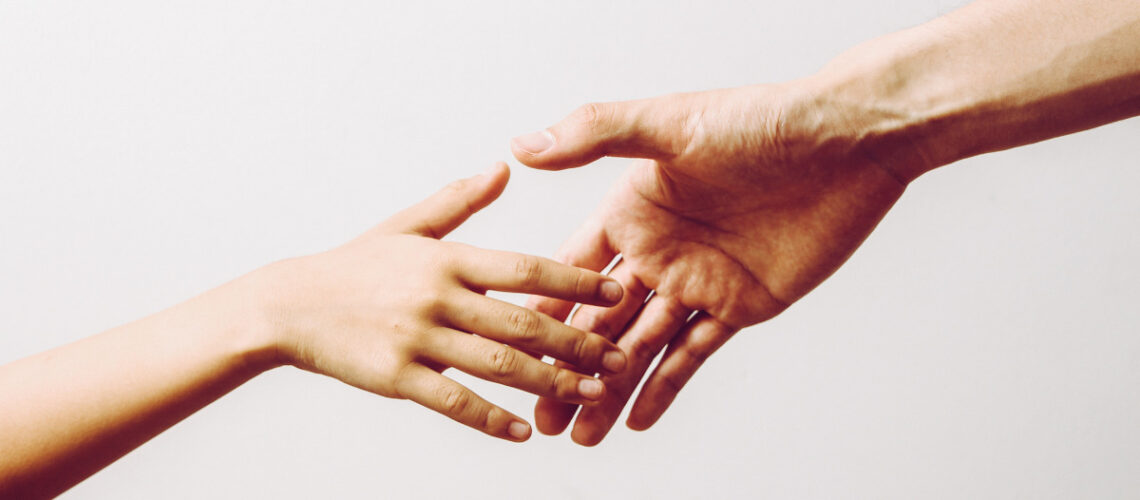 Two hands reaching out to one another