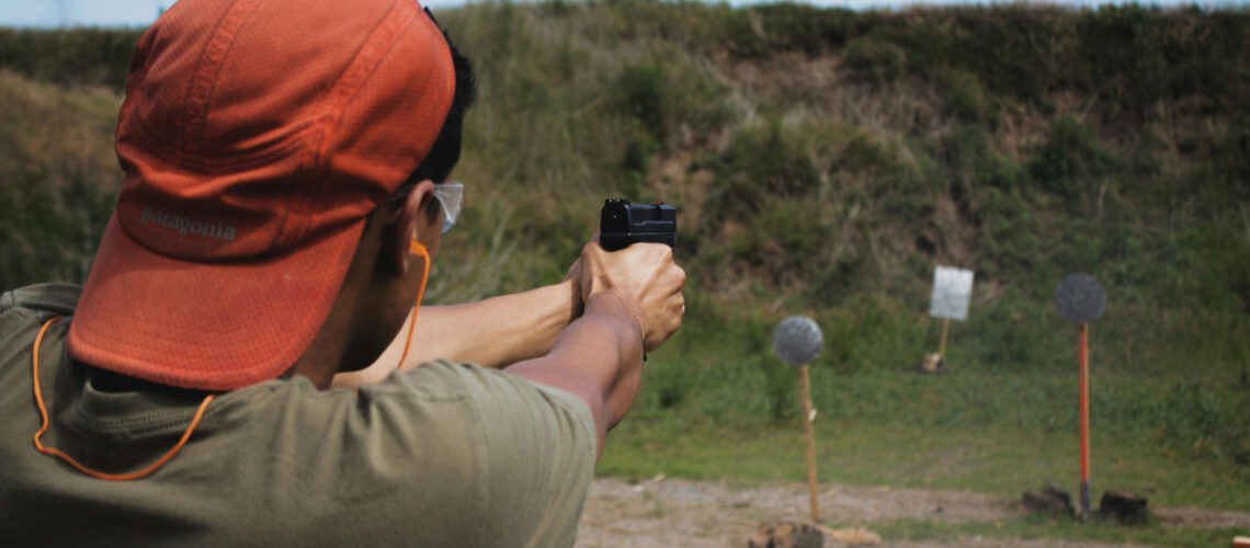 a man shooting a gun at a firing range