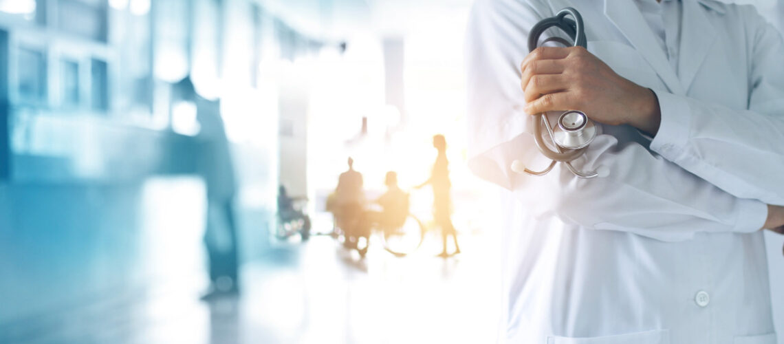 Medical professional in a white lab coat in hospital setting.