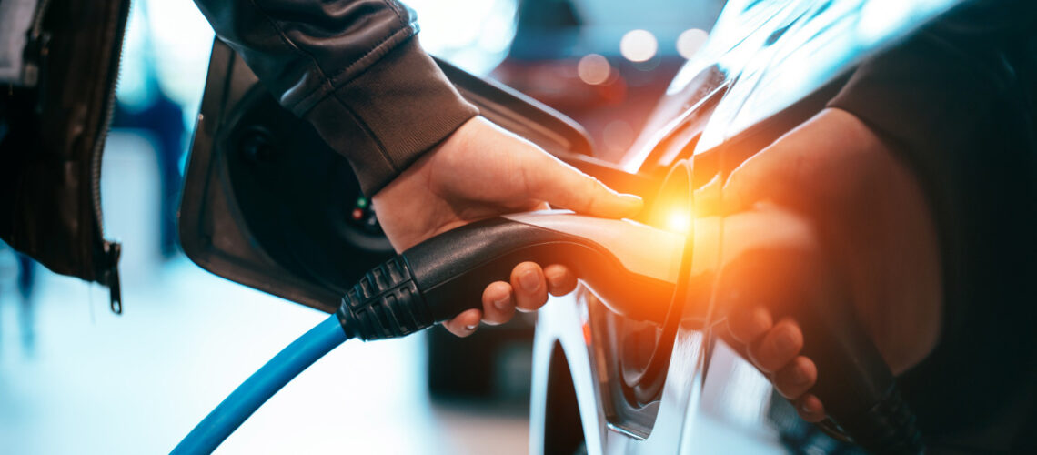Individual charging their electric vehicle.