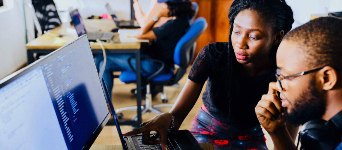 woman and man working at a tech startups office on a computer
