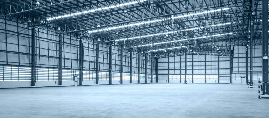 brightly lit empty warehouse with multiple bays